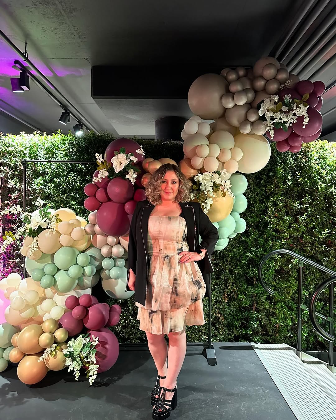 Yuliya standing in front of a colorful balloon installation